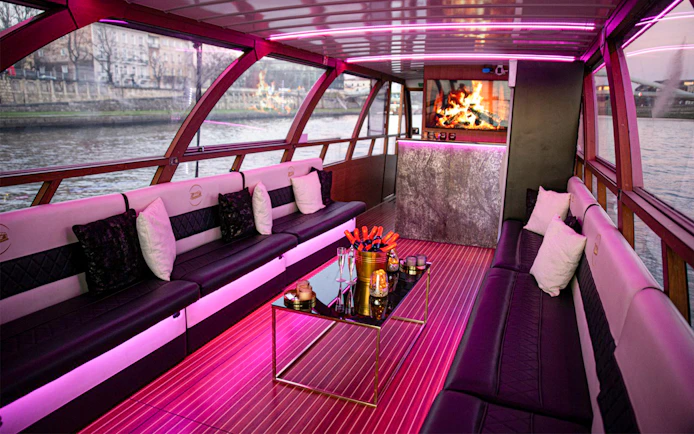 Interior of the Vistula River Cruise catamaran in Krakow with seating and a fireplace.
