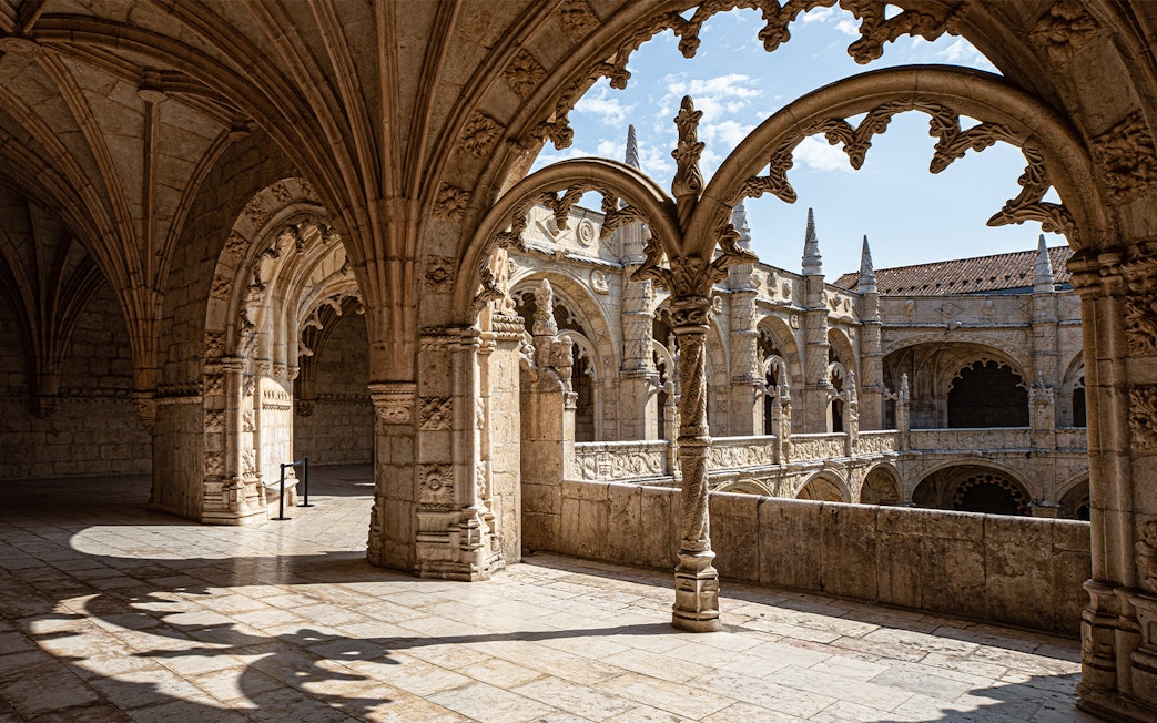 Jerónimos Monastery cloister with detailed arches and stone carvings in Lisbon, Portugal.