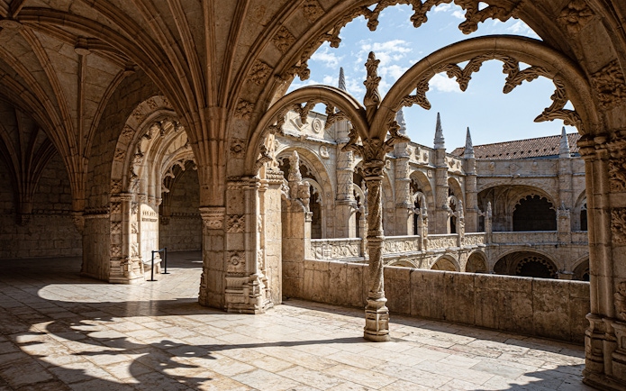 Jerónimos Monastery cloister with detailed arches and stone carvings in Lisbon, Portugal.