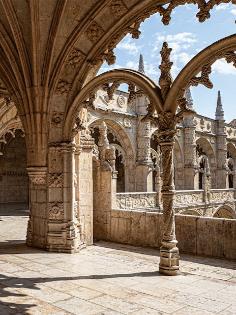 Jerónimos Monastery cloister with detailed arches and stone carvings in Lisbon, Portugal.
