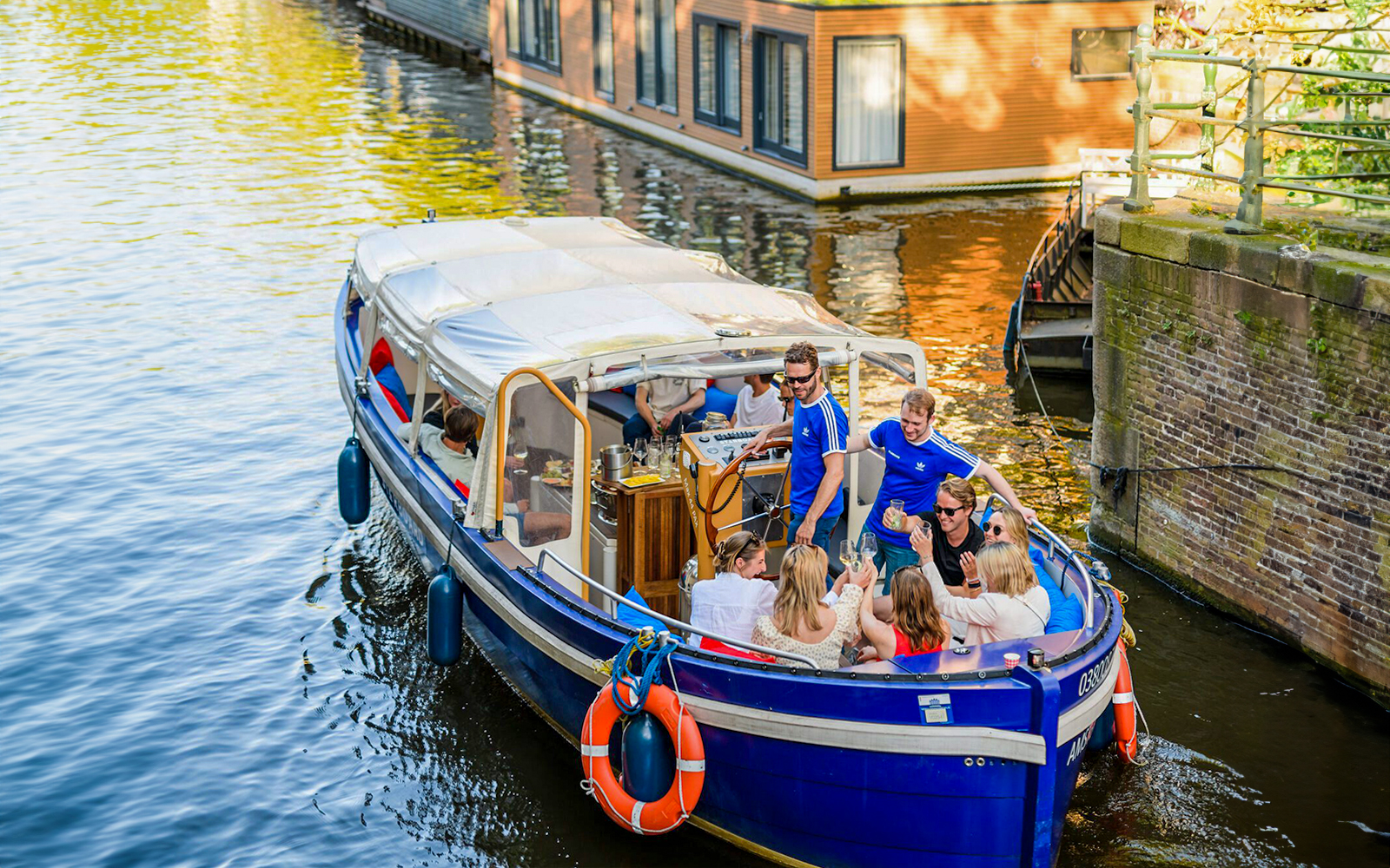 Luxury canal cruise in Amsterdam with passengers enjoying drinks.