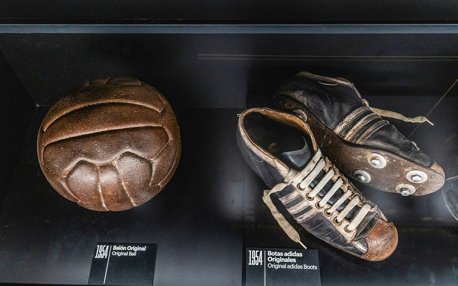 Visitors exploring the LEGENDS The Home of Football exhibit, featuring historic boots and balls used.