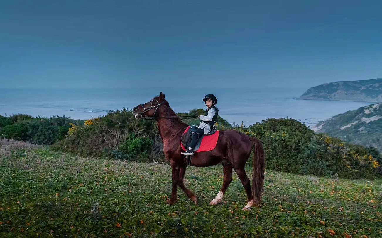 Horseback rider on coastal trail in Mnar, Tangier with ocean view.