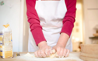 Hands kneading dough during a Genoese cooking lesson in Genoa.