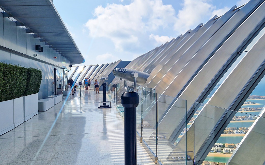 Observation deck at The View At The Palm with telescopes and cityscape in the background.