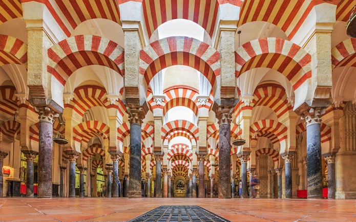 Córdoba Cathedral-Mosque interior with red and white arches and columns.