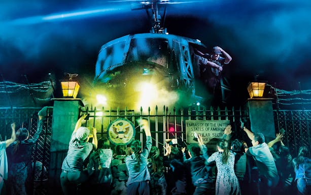 Crowd reaching towards helicopter in Miss Saigon at The Sydney Opera House.