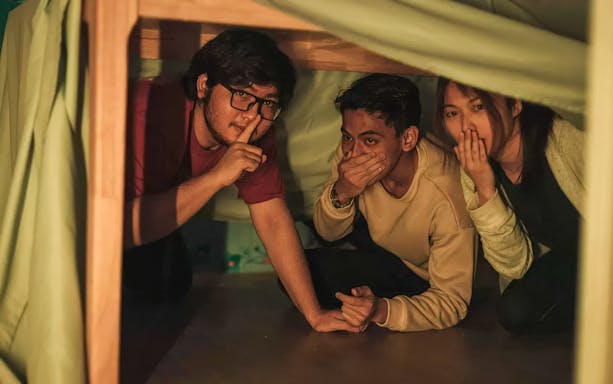 Participants hiding during Malaysia Breakout The Curve spy game experience.