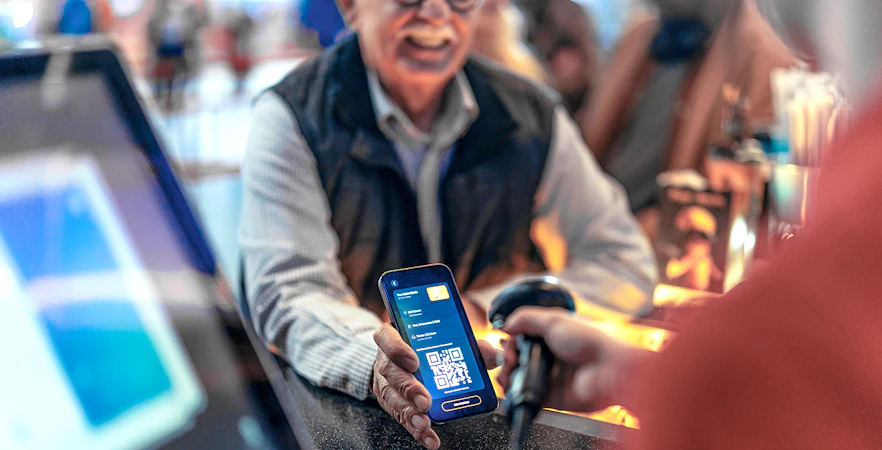 Scanning a digital voucher with a QR code at a ticket counter.