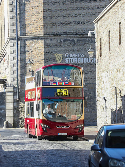 Big Bus Dublin tour passing by the Guinness Storehouse in Dublin, Ireland.