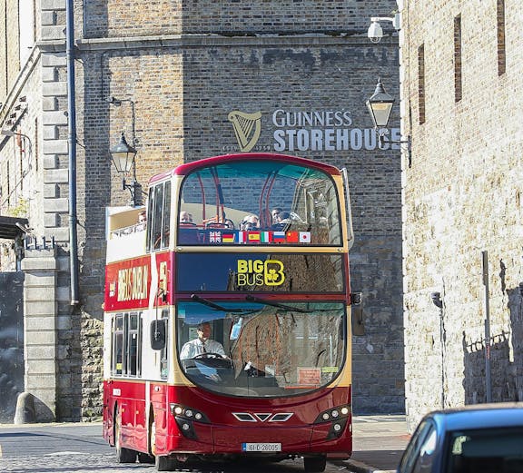 Big Bus Dublin tour passing by the Guinness Storehouse in Dublin, Ireland.