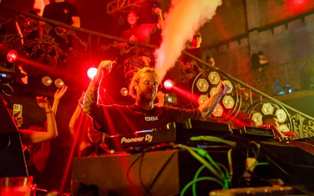 DJ performing at Atlas Super Night Club with vibrant lights and crowd.