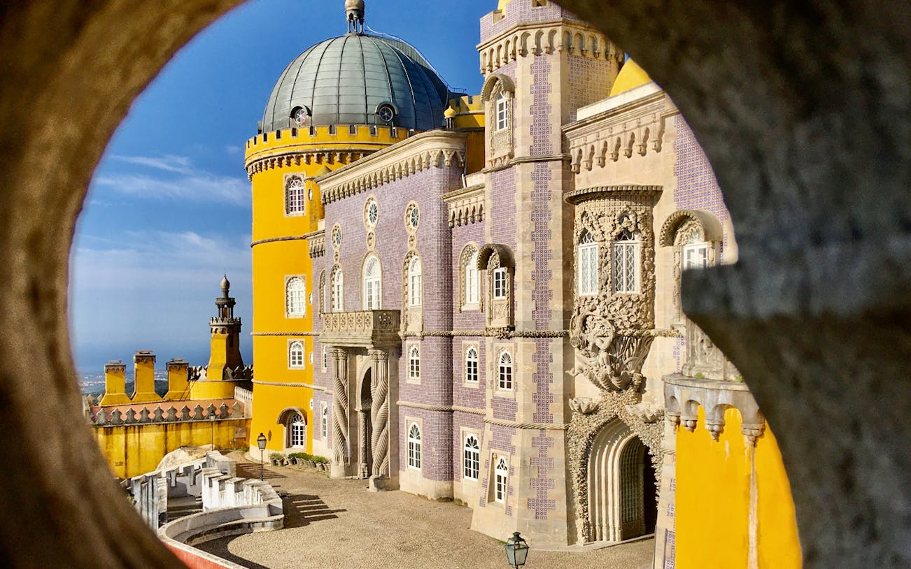 Pena Palace in Sintra with colorful facade and intricate architectural details.
