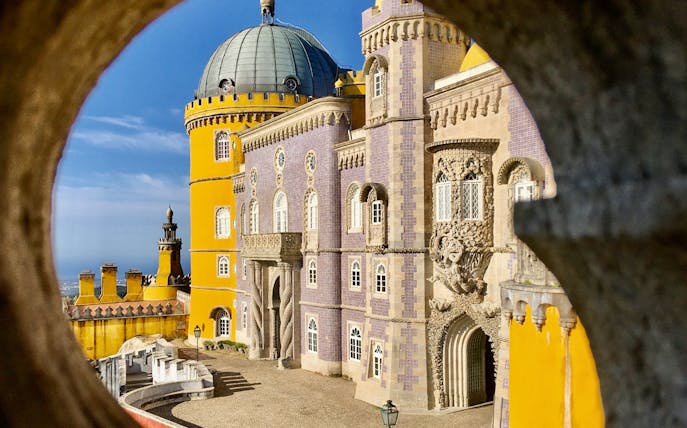 Pena Palace in Sintra with colorful facade and intricate architectural details.