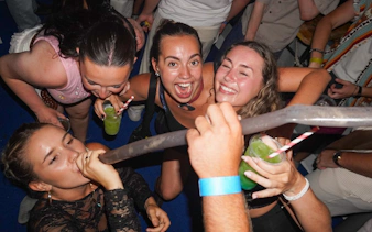 Partygoers enjoying drinks and music on a Split night boat party with live DJ.