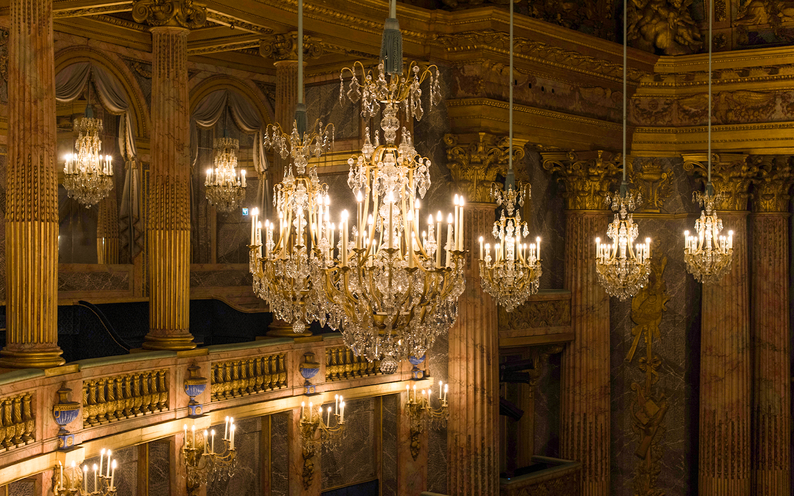 Chandelier in Royal Opera, Versailles Palace, France, showcasing intricate design and historical elegance.
