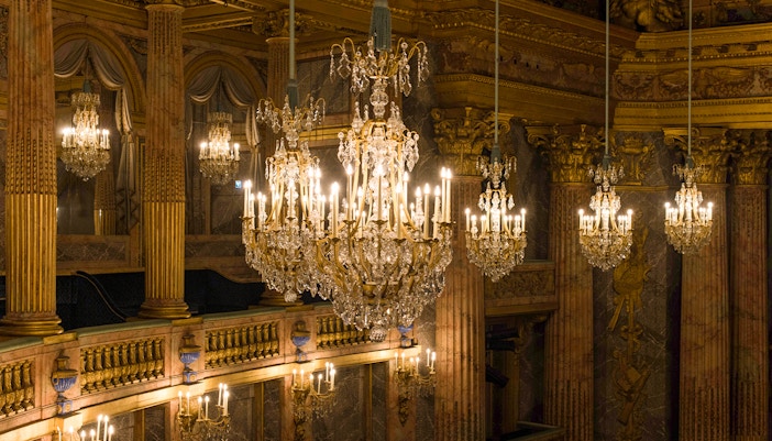 Chandelier in Royal Opera, Versailles Palace, France, showcasing intricate design and historical elegance.