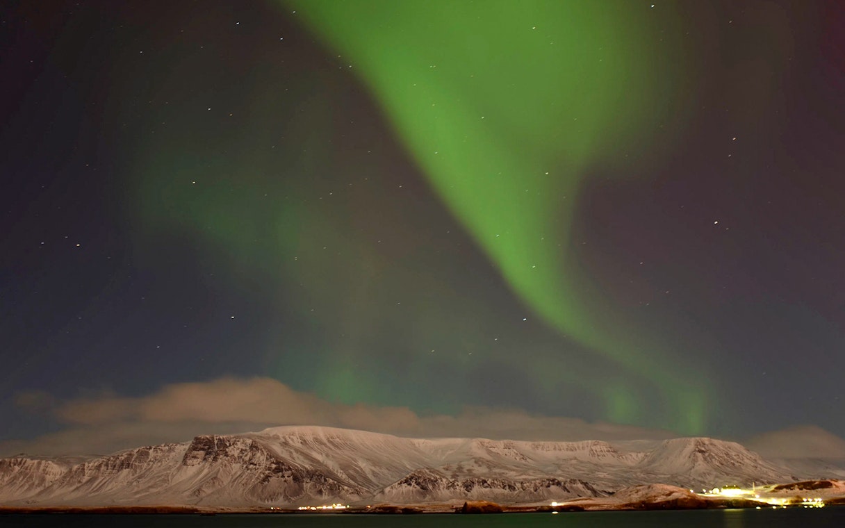 Northern Lights over snowy mountains near Reykjavik, Iceland.