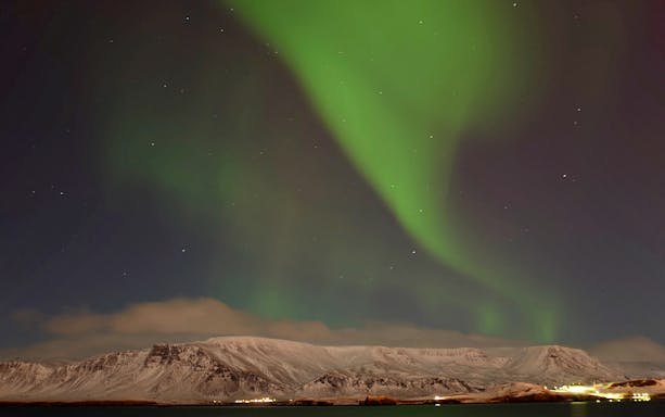 Northern Lights over snowy mountains near Reykjavik, Iceland.