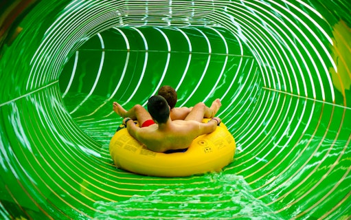 Two people on a yellow raft in the Andromeda slide, galaxy zone, Therme Bucharest.