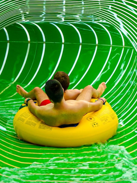 Two people on a yellow raft in the Andromeda slide, galaxy zone, Therme Bucharest.