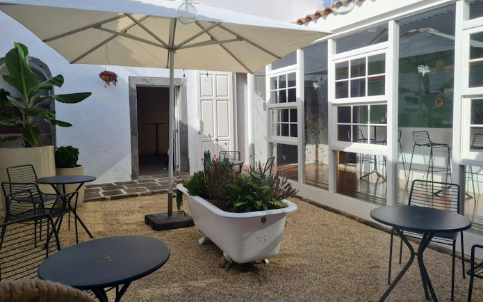 Courtyard seating area at Banana World, Gran Canaria, with potted plants and tables.