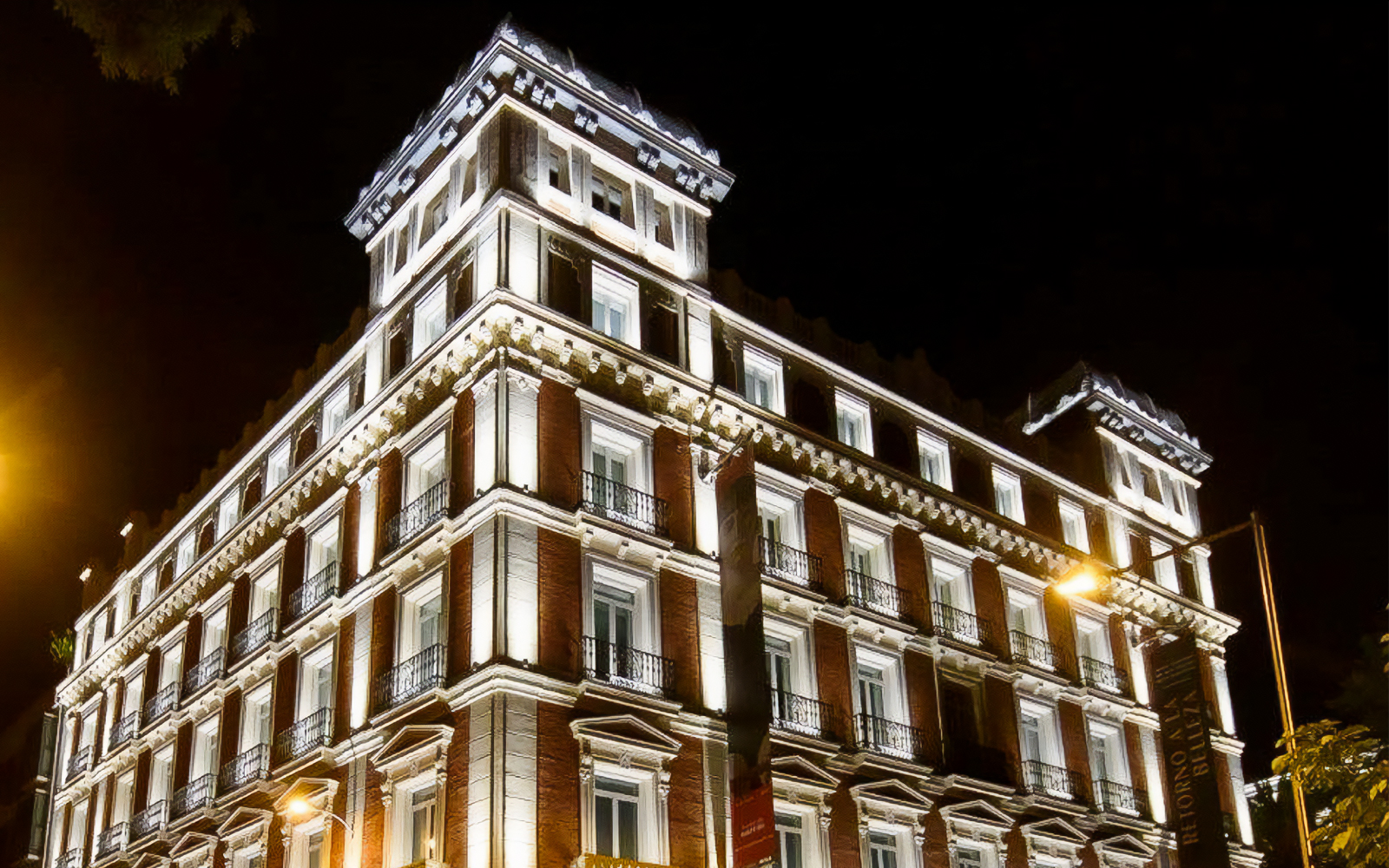 Illuminated facade of Fundación MAPFRE's Recoletos Room in Madrid at night.