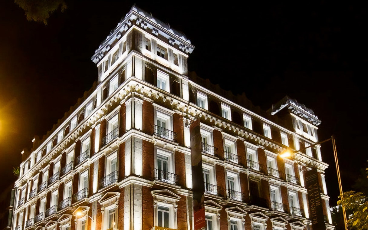 Illuminated facade of Fundación MAPFRE's Recoletos Room in Madrid at night.
