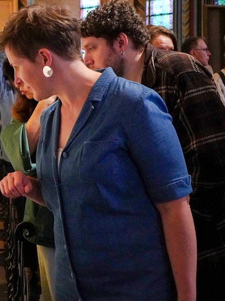 Guide examining a historical artifact inside Notre Dame Cathedral.