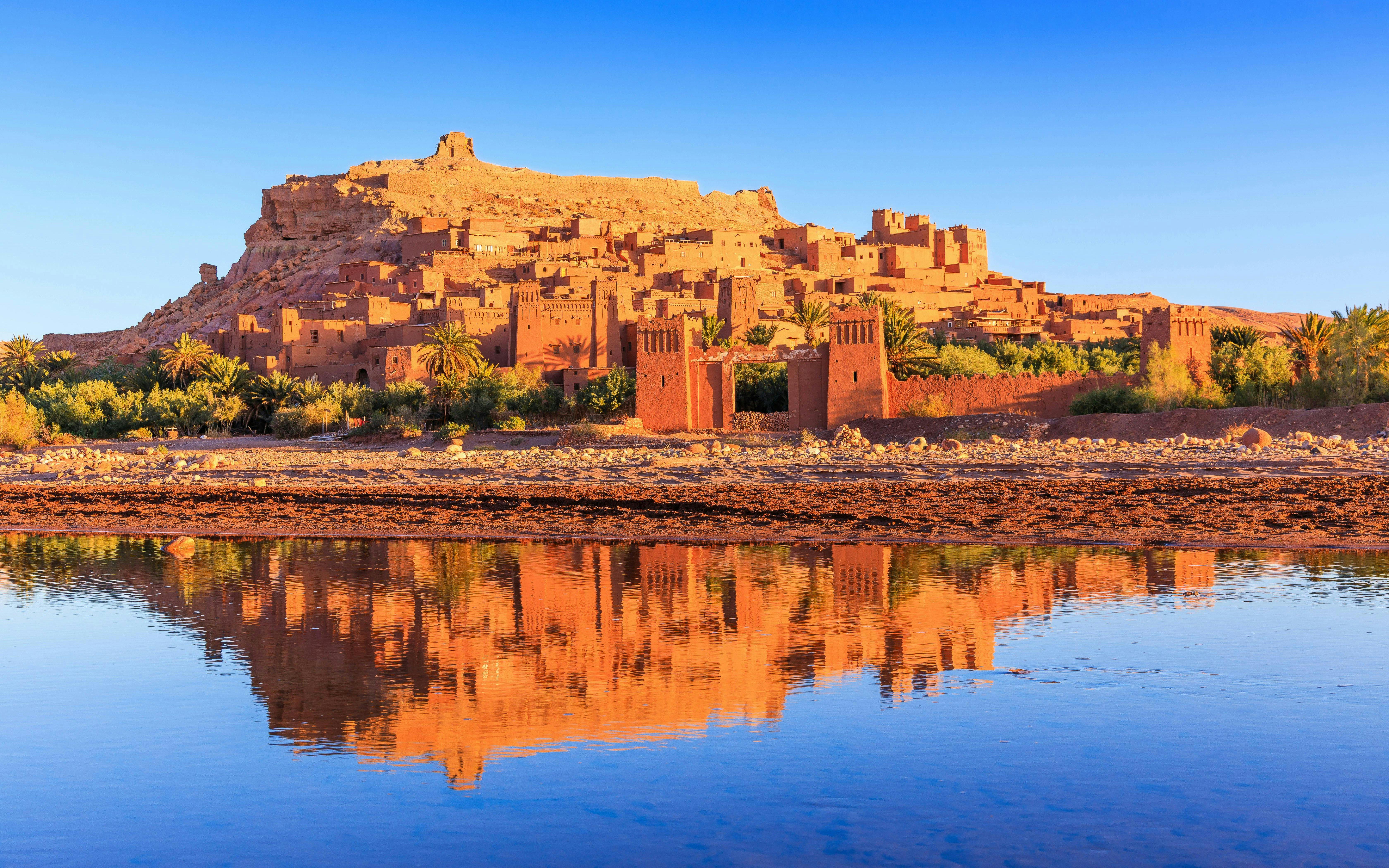 Ait-Ben-Haddou, a historic ksar in Ouarzazate, Morocco, reflected in a river.