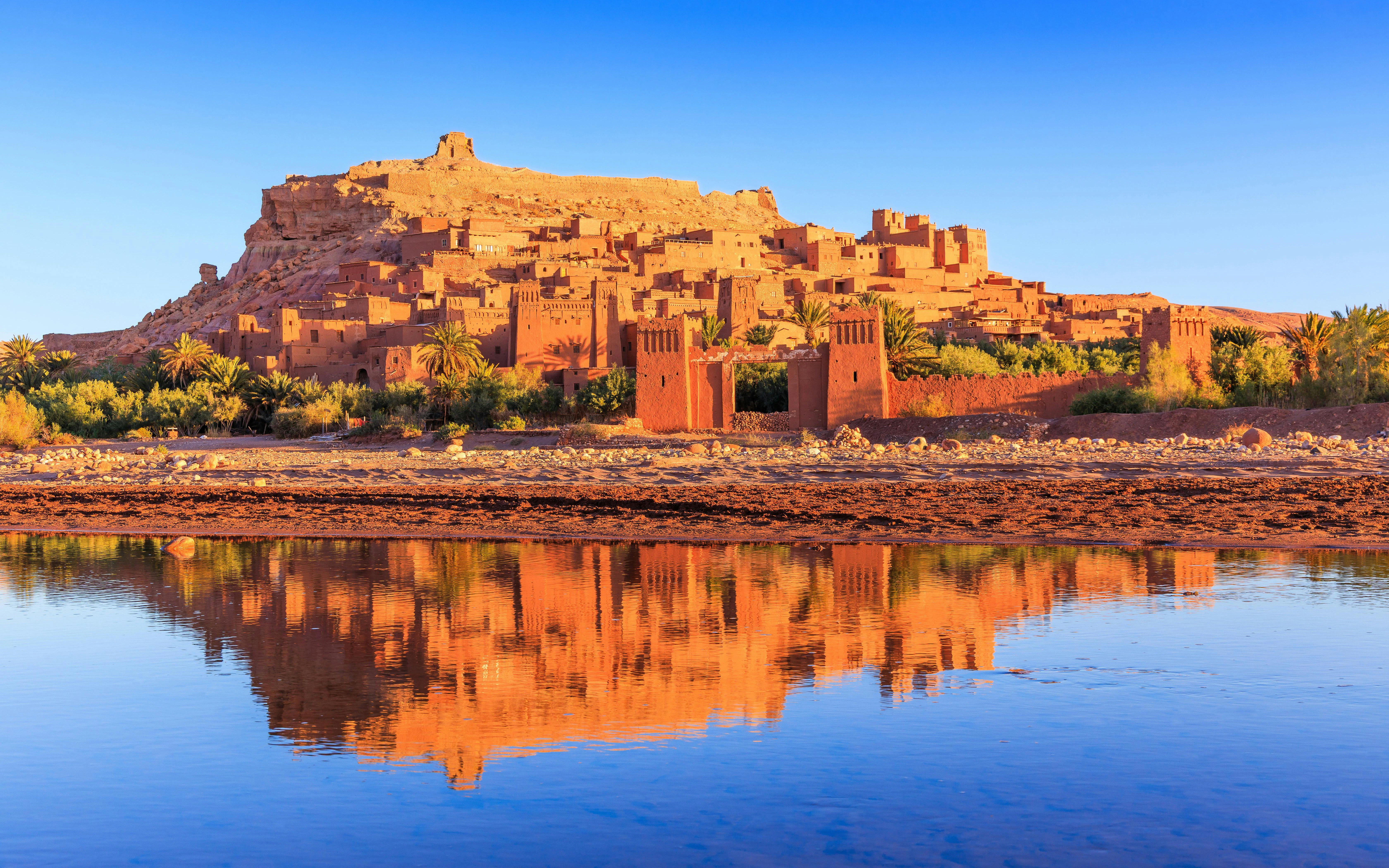 Ait-Ben-Haddou, a historic ksar in Ouarzazate, Morocco, reflected in a river.