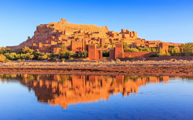 Ait-Ben-Haddou, a historic ksar in Ouarzazate, Morocco, reflected in a river.