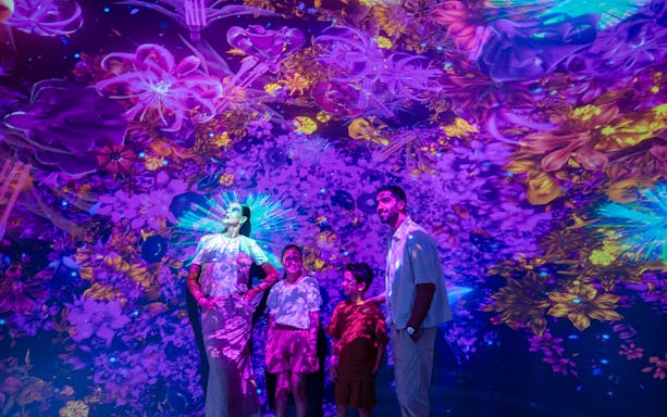 Visitors exploring the vibrant AYA Universe light installation in Dubai, UAE.