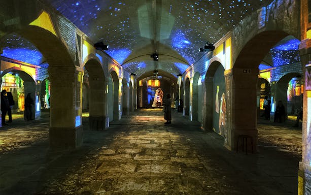 Porto Legends immersive experience with projections in a historic stone hall.