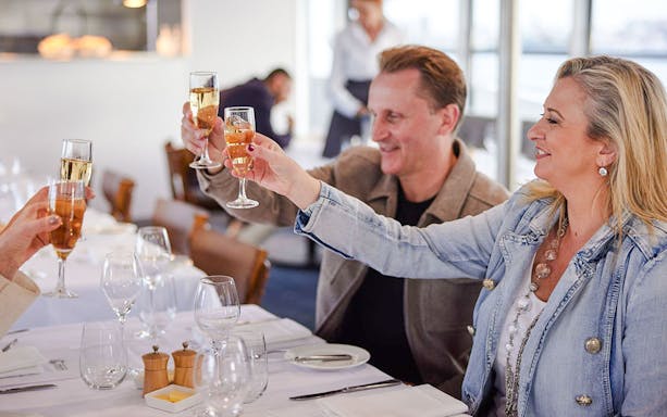 Tourists toasting with champagne on a Sydney Harbour cruise.