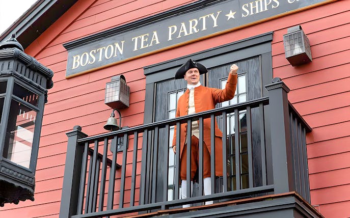 Boston Tea Party Ship and Museum exterior with historical reenactor on balcony.