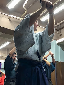 Participants practicing sword techniques during a Samurai experience in Japan.