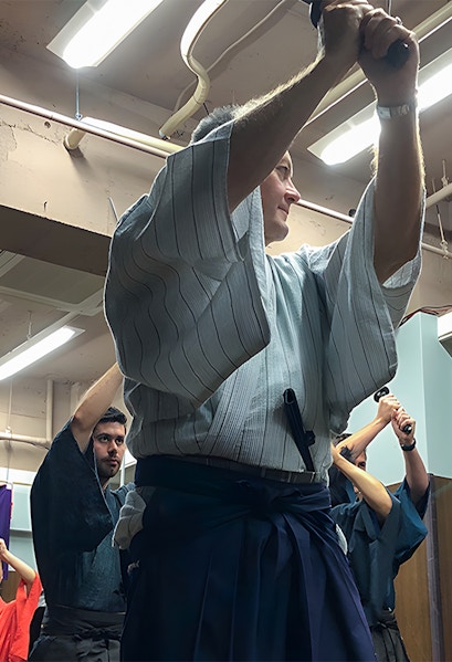 Participants practicing sword techniques during a Samurai experience in Japan.