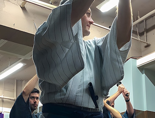 Participants practicing sword techniques during a Samurai experience in Japan.