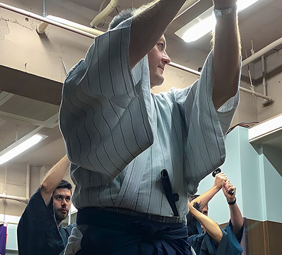 Participants practicing sword techniques during a Samurai experience in Japan.