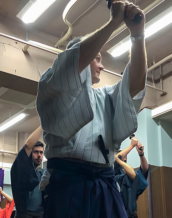 Participants practicing sword techniques during a Samurai experience in Japan.