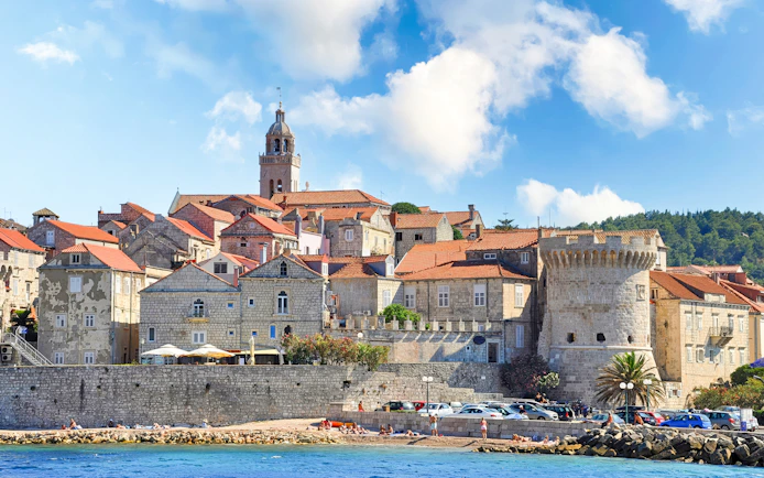 Korcula town view from the sea with historic stone buildings and tower, Croatia.