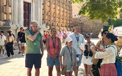 Tourists listening to a guide at the Alhambra, Granada, during a guided tour without Nasrid Palaces.