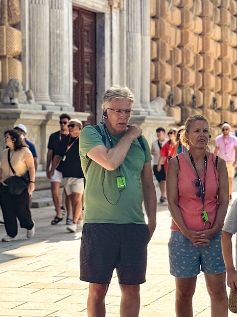 Tourists listening to a guide at the Alhambra, Granada, during a guided tour without Nasrid Palaces.