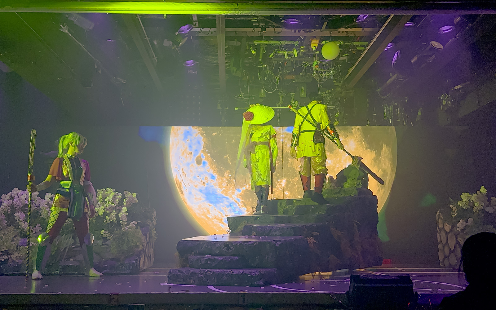Samurai performers on stage with moon backdrop at Samurai Restaurant Show.