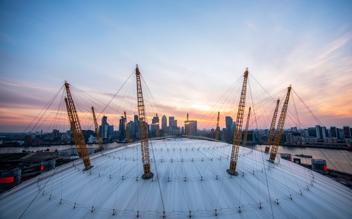 Guests enjoying sunset view at The O2 Arena, London, with city skyline in the background.