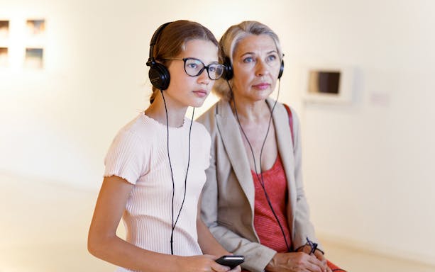Tourists using audioguides at the Louvre Museum in Paris, France.
