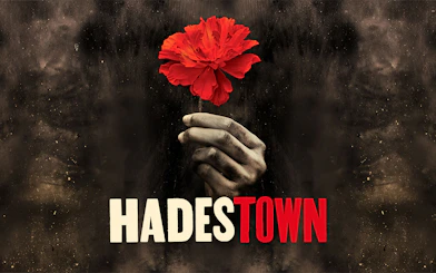 Hand holding a red flower with "Hadestown" text, West End production.