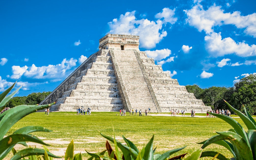 Chichen Itza pyramid with tourists exploring the site in Mexico.