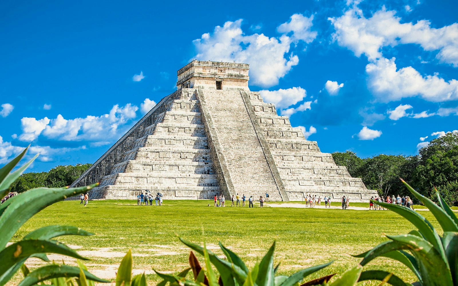 Chichen Itza pyramid with tourists exploring the site in Mexico.